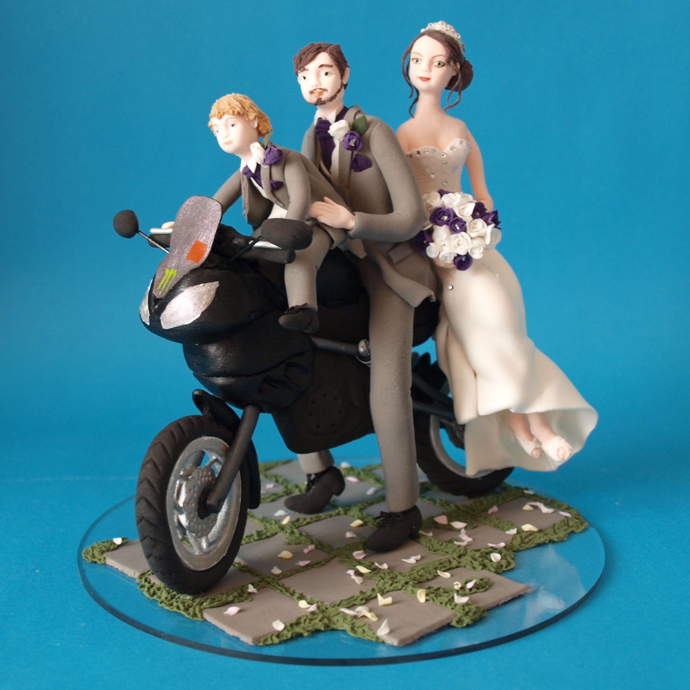 Bride and groom with child on a motorbike wedding cake topper by Louisa Hill