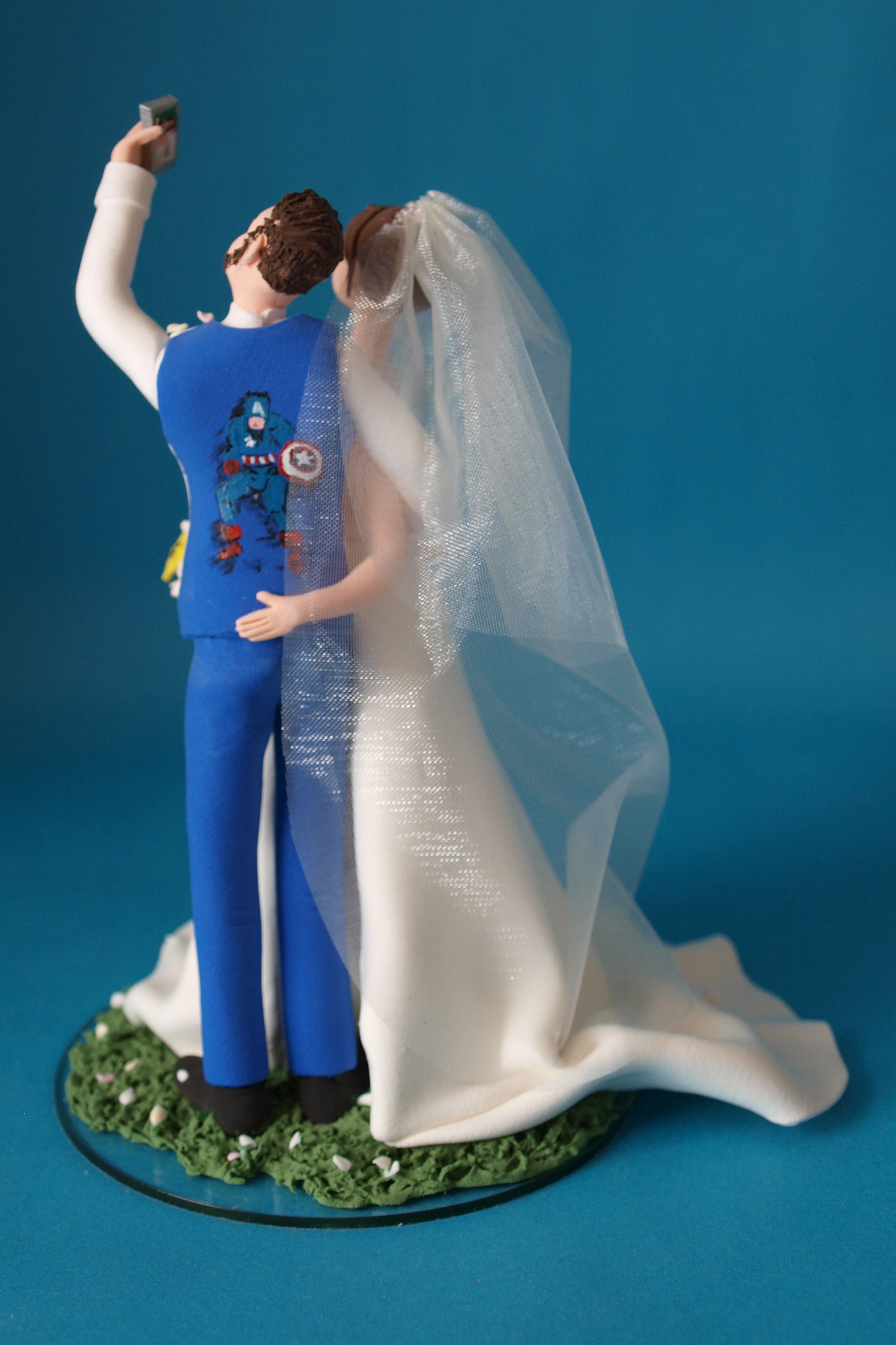 Bride and groom with Captain America waistcoat wedding cake topper with cats by Louisa Hill