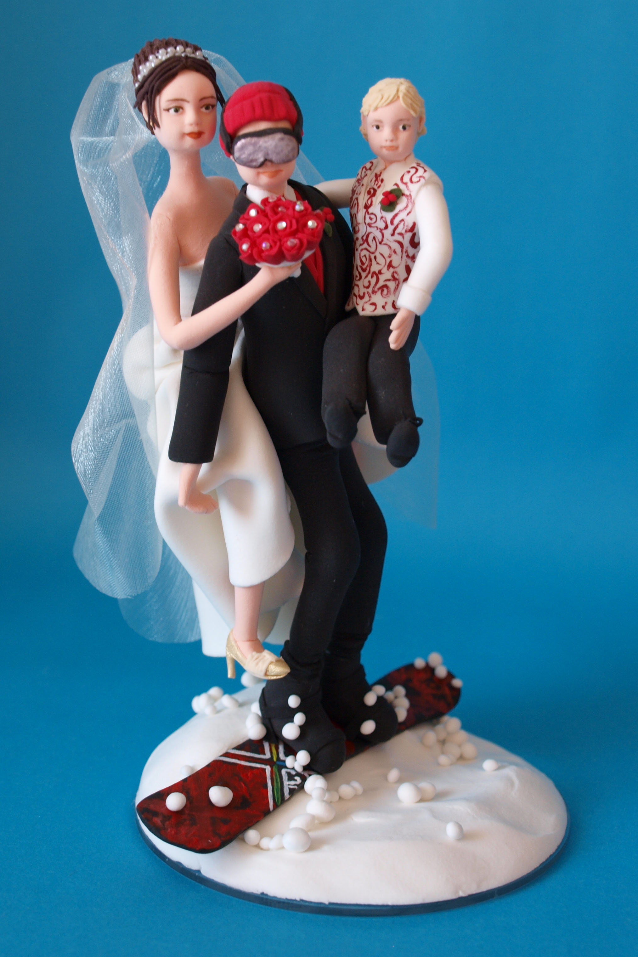 Snowboarding bride and groom with child wedding cake topper by Louisa Hill