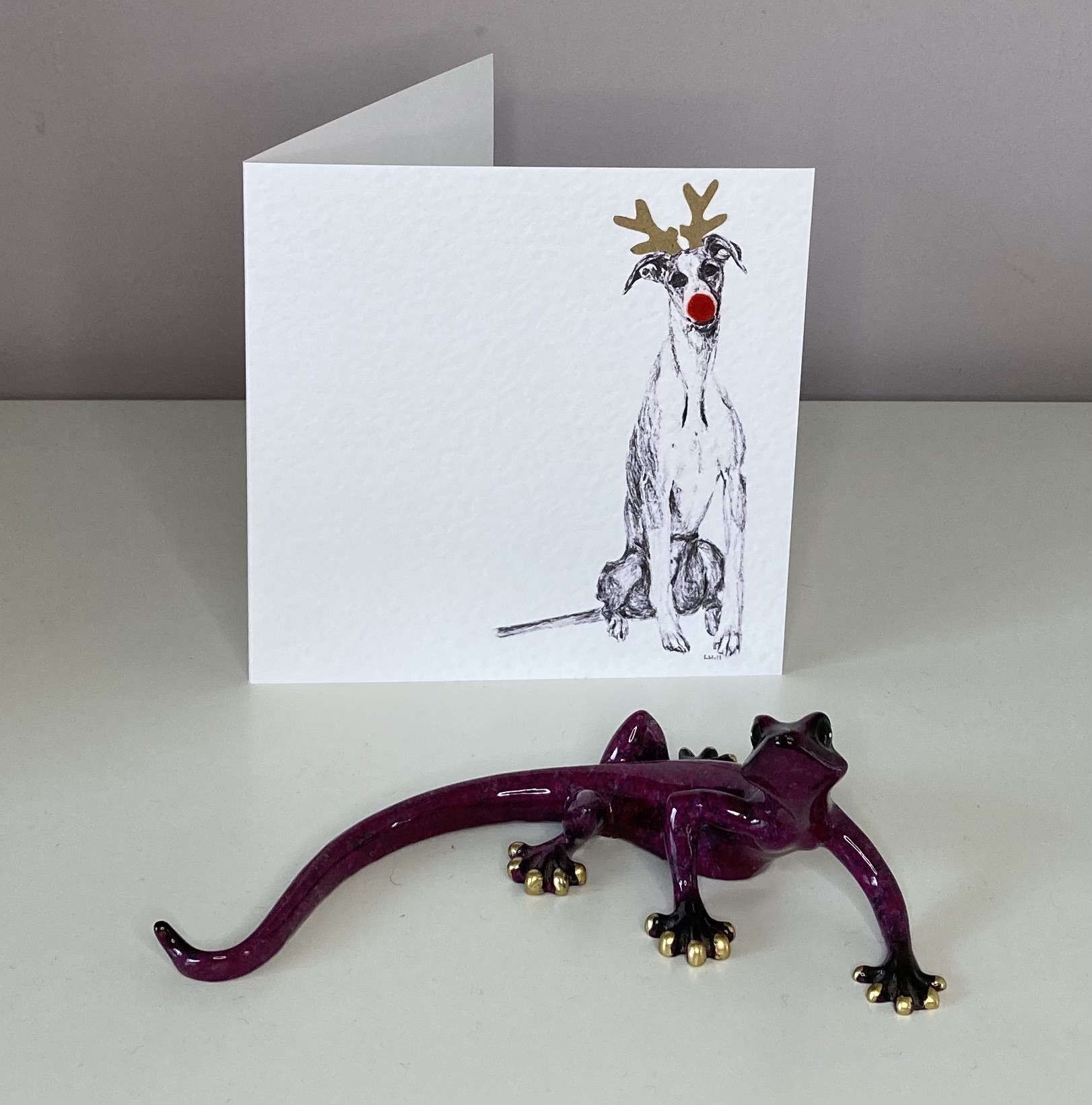 Whippet with reindeer antlers and red nose Christmas card by Louisa Hill