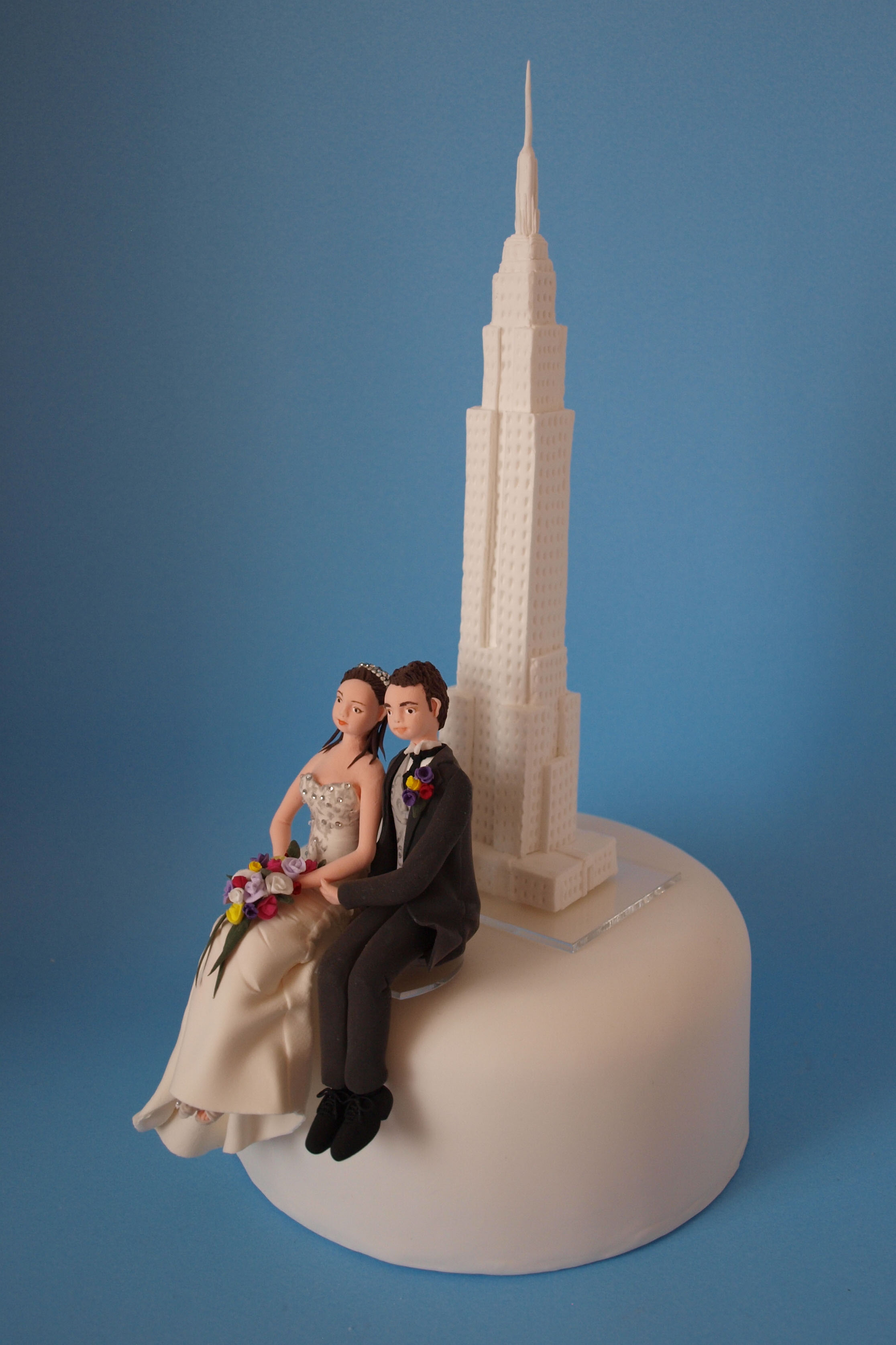 Bride and groom with Empire State Building wedding cake topper by Louisa Hill