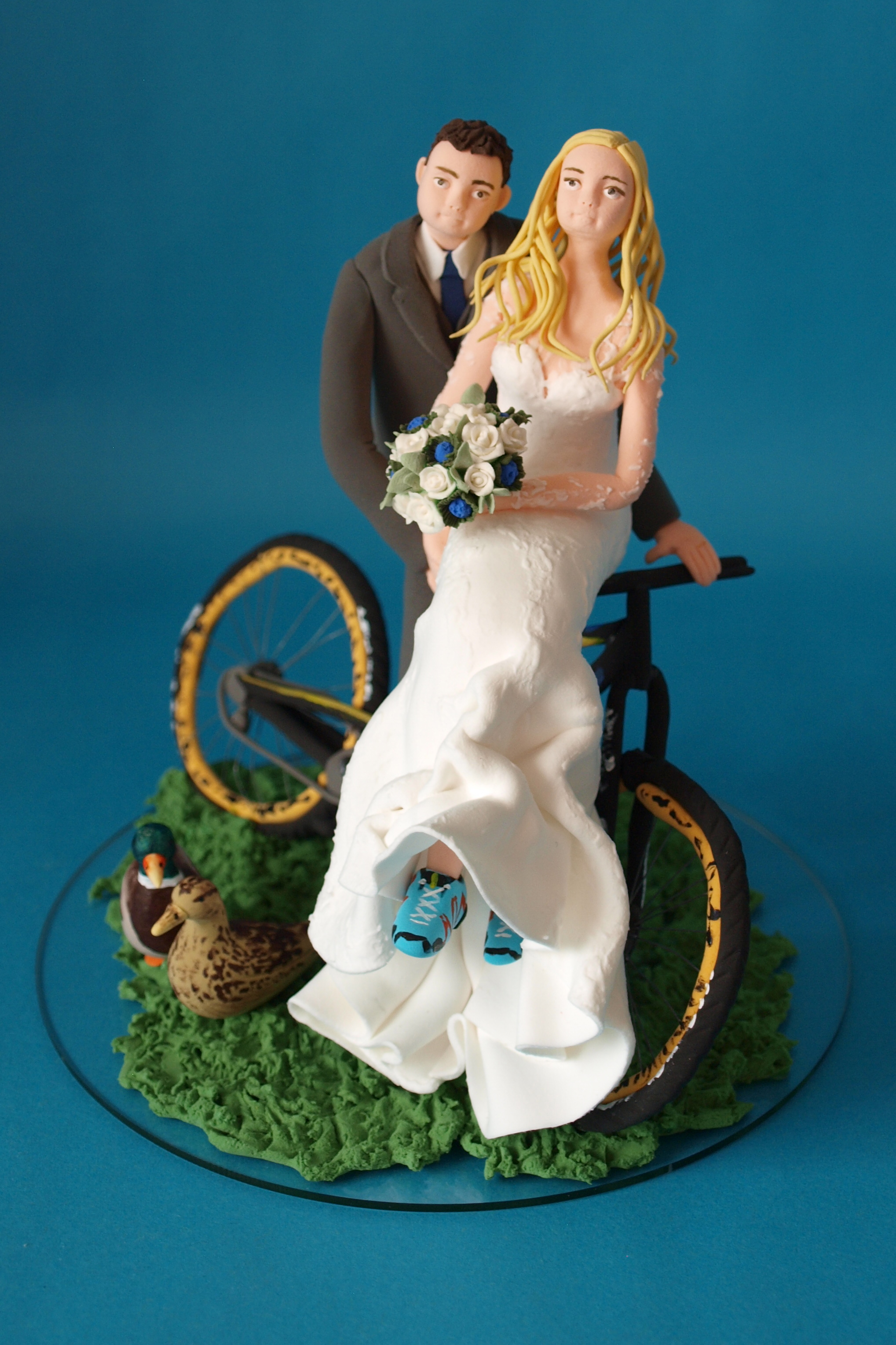 Bride and groom with a bicycle wedding cake topper by Louisa Hill